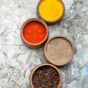vertical-view-different-spices-brown-bowls-gray-background-min